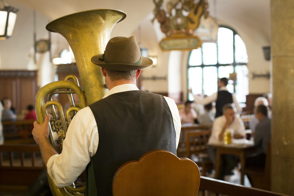 A man in traditional outfit playing his instrument at Hofbräuhaus in Munich, Germany