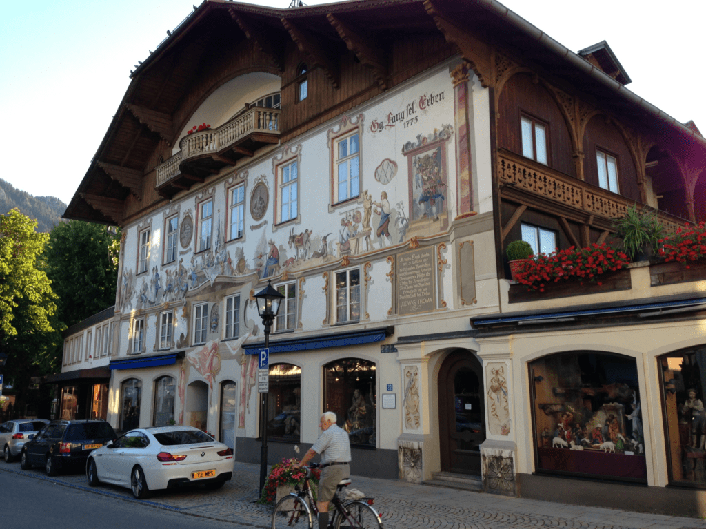 House with intricate exterior wall paintings depicting people performing traditional trade jobs